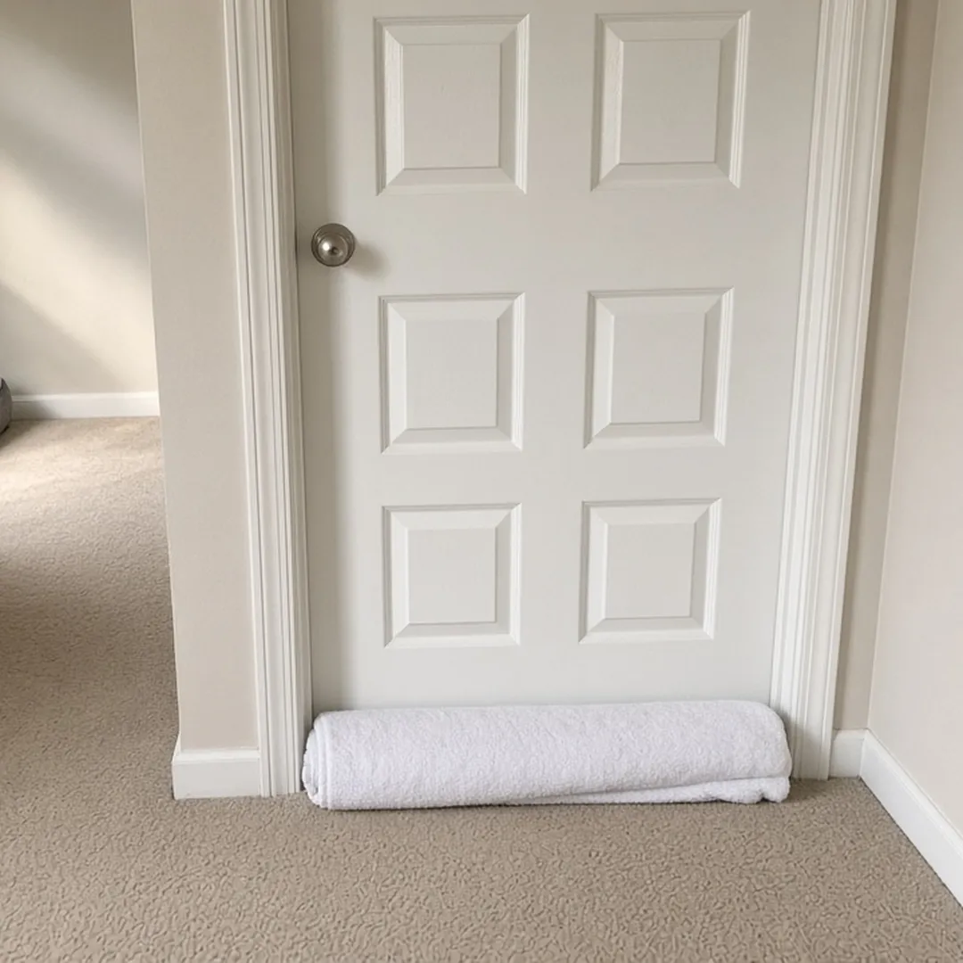 Closed interior door in a quiet Arlington home with a towel placed along the gap at the bottom